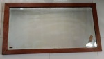 Grande espelho de parede em cristal bisotado, com moldura em madeira (pequenas perdas no revestimento). Mínimas manchas causadas pelo tempo. Med. 143x80cm.