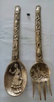 BRONZE - Lote com (2) talheres decorativos em bronze maciço, cinzelado com riqueza de detalhes, apresentando decoração Argentina com cenários regional em relevo, sendo: um garfo e uma colher. Medidas: maior: 43 cm de comprimento/ menor: 40 cm de comprimento. Possui pequenas marcas do tempo.