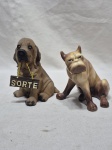 Lote de 2 enfeites na forma de cachorro, sendo um em resina e um em porcelana. Medindo o maior 13cm de altura.