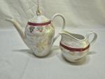 Lote de bule e leiteira em porcelana Abece furtacor vinho com friso ouro. Medindo o bule 15cm de altura. Peça com leves desgaste no friso.