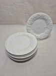 Jogo de 7 pratos de sobremesa em porcelana branca com relevos na borda. Medindo 20cm de diâmetro.