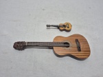 Lote de 2 miniaturas de violão e cavaquinho em madeira. Medindo o maior 21cm de comprimento, pequeno restaurado.