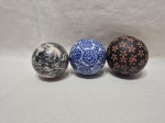 Lote de 3 bolas decorativas sendo em porcelana, pedra e cerâmica. Medindo a maior 6,5cm de diâmetro.