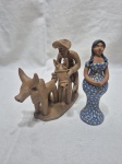 Lote de 2 enfeites, esculturas em terracota, sendo uma pintada. Medindo o maior 15cm de altura.