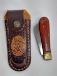 Lindo e Conservado Canivete com Cabo em Madeira. Acompanha Bainha em Couro Legítimo. Medida aberto: 18 cm x 2,5 cm x 1,5 cm.  Medida da Lâmina: 8 cm de comprimento. Conforme fotos.