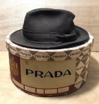 PRADA - Antigo chapéu em couro, camurça e cetim - 55cm de circunferência - 10x30x26 cm medidas gerais - acompanha caixa - chapéu e caixa com amarelados pela ação do tempo e leves desgastes do uso e manuseio.