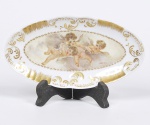 Vista Alegre - delicado covilhete em porcelana com borda dourada estilo Velho Paris e medalhão ao centro com cena de cupidos pintado à mão, assinado e datado Ma Thereza 76 - 20X11 cm