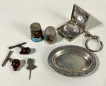Sete peças em metal prateado, sendo dois dedais, um chaveiro com fotos um pratinho duas abotoaduras e um boton. Medida do pratinho  7 x 5 cm