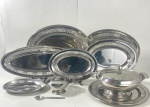 Conjunto de dez peças em aço inox marca ART PRATA, com barrado cinzelado, contendo: Sopeira com presentoir , (18 x 26 cm de diâmetro) e presentoir (35,5 cm), molheira com colher  (11 x 14 cm ), covilhete (3 x 18 x 26 cm), travessa (33 x46), travessa (30 x 41,5 cm ), travessa (26 x36,6cm), travessa (21,5 x 31,5) travessa (18 x 26 cm )