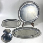 Cinco peças em inox, contendo: Travessa de peixe (50 x 23 cm ), Travessa (35 x 24 cm ) Travessa redonda ( 40 cm ), Prato (16 cm ) e tampa (11 cm).