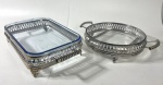 Duas travessas em vidro com suportes em metal prateado. Medidas:  28 cm / 23,5 x 39,5 cm. Pequeno lascado na travessa retangular parte da pega.