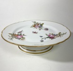 Reinemer e Gallé - Elegante prato raso elevado, "fruteira"  em porcelana branca com rica decoração floral multicolorida com tons de rosa verde e dourado. Bordas suavemente onduladas com filete dourado e pé circular em degrau também com filete dourado. Medidas: 6 x 22 cm. Reinemer e Gallé - Charles Gallé ( pai de Emile Gallé )  iniciou sua pequena manufatura logo após que sua sogra ficou viúva, ele adquiriu 50% da pequena sociedade familiar. Este é o primeiro período da empresa que viria a ser conhecida no mundo inteiro como "Gallé "e que mais tarde passou para as mãos de seu filho o genial artista do período Art Nouveau Emile Gallé . Nesse primeiro momento eles produziam cerâmicas artísticas com desenho próprio e de extrema qualidade dos quais ganharam vários prêmios, conquistando o privilegio de vender para o imperador Napoleão III, uma honra para a época,  Essas peças hoje raríssimas de serem encontradas, são peças de museu, marcadas no fundo Veuve Reinemer e Galle esse pequeno período podemos afirmar que datam de 1846 a 1854.Informações complementares podemos encontrar no livro "O Art Nouveau de Èmile Galle e seus contemporâneos, de André Guarisse".