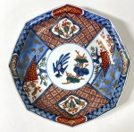 CIA DAS ÍNDIAS- IMARI-JAPÃO SÉCULO XIX - Centro de mesa octogonal de bordas recortadas, em porcelana decorada no tradicional estilo Imari, com paleta em azul cobalto, vermelho-ferrugem e dourado, apresentando reservas florais e composição central com pássaro e folhagens. Peça de grande presença decorativa, típica da produção oriental destinada à exportação. Apresenta fio de cabelo. Medidas: