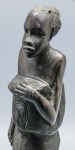 ESCULTURA - Linda escultura, esculpida em ébano, representando Mulher e crianças, vestindo trajes étnicos. Alt. 31 cm.