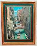 QUADRO - Pôster de Veneza com canal, gôndolas, pontes e prédios antigos. Moldura dourada com bordas verde, vermelha e preta. Cena ensolarada e colorida. Envidraçado e emoldurado. Med. 80x65 cm.