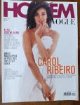 Revista HOMEM VOGUE  Ano 8, Nº 26 Capa com Carol Ribeiro por J.R. Duran, em homenagem a Marilyn Monroe. Destaques sobre Roger Federer, Grazi Massafera, consumo sofisticado (barcos, carros, restaurantes em NY), e histórias inspiradoras de sucesso.