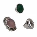 Três anéis em prata, um deles contrastados com pedras topázio aro 19, cristal aro 19 e verde sintética aro 15, 66,8 g. bruto.