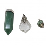Três pingentes com castão de prata sendo um com quartzo verde, um cristal e uma concha,  Alt. 6 a 3 cm. 83 g. bruto,