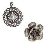 Dois pedantifes em prata 925  sendo um de filigrana com cascalhos de brilhante e uma pedra perolada,   e outro representando flor, Diam. 5 e 4 cm. 39,3 g. bruto