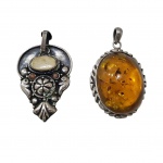Dois pedantifes em prata ambos contrastado 925, um deles assinado Rick joias, com marfim e outro com pingente âmbar, 5 x 3 e 5 x 4 cm. 31,5 g.