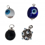 Quatro berloques com pegas em prata sendo 3 olhos turcos  e  um ônix lapidado, Diam. 2 cm.