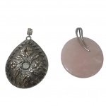 Dois pedantifes, um em quartzo rosa e metal prateado, outro em metal prateado lavrado e repuxado em flores e desenhos simétricos, 8 x 7 e Diam. 7 cm.