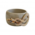 Pulseira em acrílico beje decorado com serpente dourada cos strass, Diam. 7 cm.