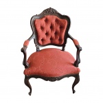 Poltrona Luiz XV executada em Jacarandá espaldar com medalhão central, o estofamento em capitonet em perfeito estado na tonalidade bordô arrematados por tachas. Com. 60 x  Prof. 48, Alt. 100 cm.