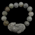 Pulseira feita com esferas e dragão esculpido em jade. Largura: 2,5cm