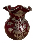 Delicado vaso em vidro soprado vermelho com aplicações em prata nas bordas e no feitio de buquês de flores. Altura: 13cm Diâmetro: 11cm