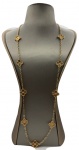 Longo colar em metal banhado a ouro adornado por 9 motivos "trevo de quatro folhas" modelo semelhante ao da joalheria Van Cleef e Arpels. Comprimento fechado: 41,5cm