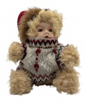 Bebê de porcelana, provavelmente europeia, com roupa de urso. Altura da boneca: 16,5cm