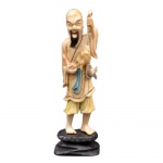 Escultura de marfim policromado, representando pescador oriental. Base de madeira. Altura: 14,8 cm