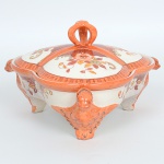FAIANÇA JAPONESA, uma (1) antiga petisqueira, formato trilobado, possui divisória, pés modelados em pássaros, pega da tampa lembra uma coroa, ornamentação policromada pintada a mão em elementos vegetalistas, possui o craquelê característico do envelhecimento de toda a faiança, marca representada pela letra H dentro de losango, encimada pela marca de origem NI-PON em caracteres, abaixo dois caracteres não identificados, medindo aproximadamente 17,5 cm diâmetro, sinais de uso, vide foto.FAIANÇA JAPONESA, uma (1) antiga petisqueira, formato trilobado, possui divisória, pés modelados em pássaros, pega da tampa lembra uma coroa, ornamentação policromada pintada a mão em elementos vegetalistas, possui o craquelê característico do envelhecimento de toda a faiança, marca representada pela letra H dentro de losango, encimada pela marca de origem NI-PON em caracteres, abaixo dois caracteres não identificados, medindo aproximadamente 17,5 cm diâmetro, sinais de uso, vide foto.