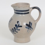 CERÂMICA ALEMÃ, uma (1) cremeira pintada a mão na tonalidade azul sobre fundo cinza, representando listras e flores, traz a águia, simbolo da cidade de Frankfurt, medindo aproximadamente 13 cm altura, vide foto.