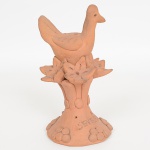 ARTE POPULAR ANIMALISTA, uma (1) escultura (paliteiro), modelada em barro e cozida, representando pássaro no ninho, assinada em cavo SEVERINA, medindo 19,5 cm altura, vide foto.