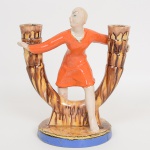 FAIANÇA AUSTRÍACA, um (1) antigo candelabro, Art Deco, para dois lumes, modelado com figura feminina central, origem marcada em cavo, medindo 26 cm altura, sinais de uso, vide foto.