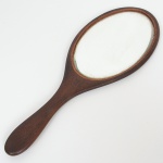 DIVERSOS, um (1) antigo espelho de mão em cristal bisotado, suporte em madeira, apliques em flores de metal prateado, medindo 36 cm comprimento, sinais de uso, vide foto.