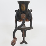 DIVERSOS, um (1) antigo moedor de grãos, confeccionado em ferro fundido, marca MIMOSO, selo da Fundição Progresso, SP, para fixação em bancada, manivela com cabo em madeira torneada, medindo 25 cm, sinais de uso e oxidação, vide foto.