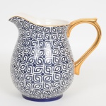 PORCELANA, uma (1) jarra refresqueira ornada em geométricos e estrelas na tonalidade azul, alça com generosos arremates a ouro, marca LE LIS BLANC CASA, medindo 19 cm altura, vide foto.