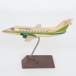 COLECIONISMO, um (1) avião miniatura, modelo EMB120 Brasília, no suporte expositor com base em madeira, medindo 16,5 cm comprimento, vide foto.