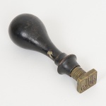 BRONZE, um (1) antigo sinete monogramado com as iniciais MA, cabo em madeira torneada, medindo 8,5 cm altura, sinais de uso, vide foto.