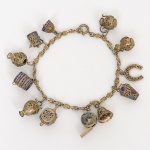 PRATA PORTUGUESA, uma (1) pulseira em prata com vermeil, contêm doze penduricalhos variados, muitos esmaltados e com trabalho em filigrana, contrastes portugueses Águia e marca de ourives, fecho do tipo boia, medindo 18,5 cm comprimento, peso aproximado 18 gr., sinais de uso, vide foto.