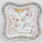 FAIANÇA PORTUGUESA, um (1) covilhete quadrangular, lobado, ornamentação policromada representando pássaros e flores, baseado na louça de Coimbra do século XVII, bicadinho na borda, medindo 10,5 x 10,5 cm, vide foto.