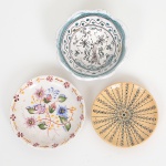 FAIANÇA PORTUGUESA, três (3) miniaturas: 1 bowl com ornamentação pintada a mão em elementos vegetalistas, baseada em louça portuguesa do século XVII; 1 prato com ornamentação floral policromada, marca de origem e assinatura PAULA no verso; 1 prato com ornamentação floral policromada sobre fundo amarelo, marca de origem e assinatura MANUELA, medindo a maior peça 9 cm diâmetro, vide foto.