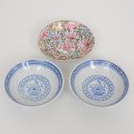 PORCELANA CHINESA, três (3) pequenos bowls: 2 (par) ornados no padrão grão de arroz (denominação dada as peças em porcelana que, após minuciosamente entalhadas com estilete, são embebidas diversas vezes em barbotina, antes da queima, para dar este efeito), tonalidade azul e branca com flores, geométricos e morcegos, marca de origem em legenda e caracteres, medindo 10 cm diâmetro; 1 com ornamentação floral policromada, pintado a mão, arremates a ouro, marca de origem Macau em legenda e caracteres, medindo 10,5 cm diâmetro, vide foto.