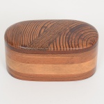 DIVERSOS, uma (1) caixa oval com tampa, confeccionada em madeiras variadas, medindo 12 x 6 x 6 cm, vide foto.