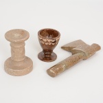DIVERSOS, três (3) itens, confeccionados em soapstone:  1 machadinha, medindo 16 cm comprimento; 1 castiçal torneado, medindo 9 cm altura; 1 porta ovo torneado, medindo 6,5 cm altura, todos os itens com sinais de uso e pequenas perdas, vide foto.