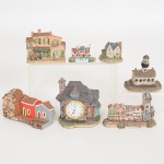ESCULTURAS, sete (7) distintos e policromados, representando edificações, confeccionados em materiais variados: madeira, cerâmica e resina, um deles com relógio quartz da marca J. M. JACMOR, medindo a maior peça, 9 cm comprimento.