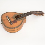INSTRUMENTO MUSICAL, um (1) antigo bandolim com 12 cordas, adquirido na Ao Cavaquinho de Ouro (Rua da Alfandega 168, RJ), com rica marchetaria com incrustações de madrepérola e madeiras diversas, medindo 55,5 cm, sinais de uso, pequenas perdas e defeitos, vide foto.